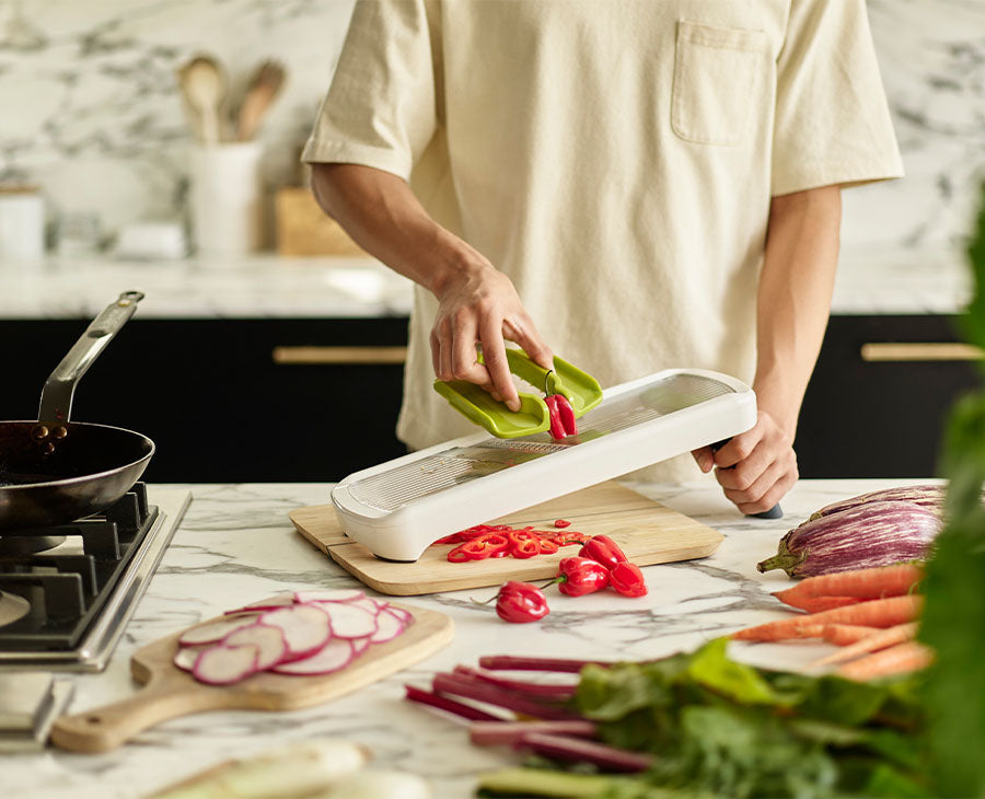 The mandoline's precision food grip holding a potato above the blade.