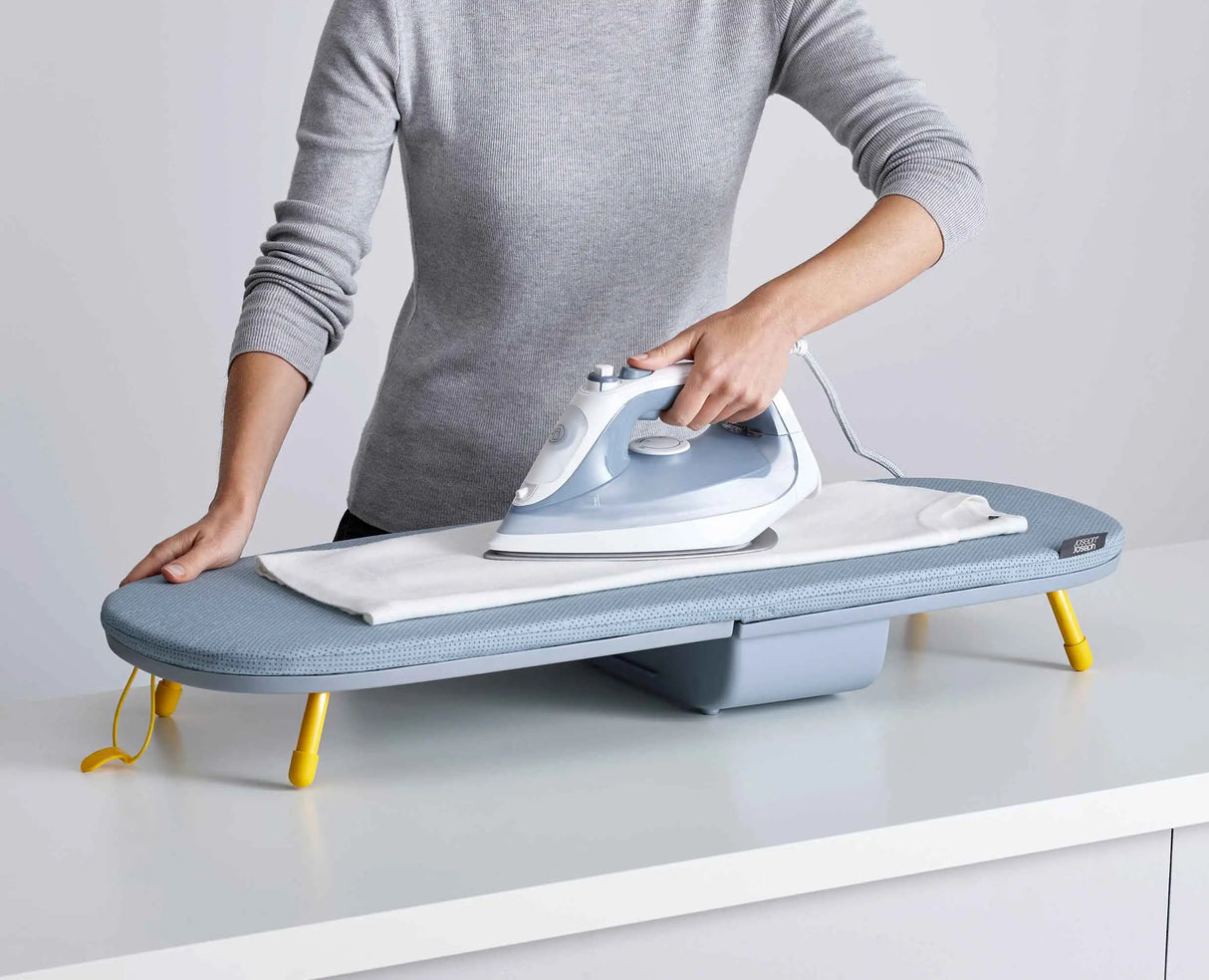 A shirt being ironed on the open Pocket board on a kitchen worktop.