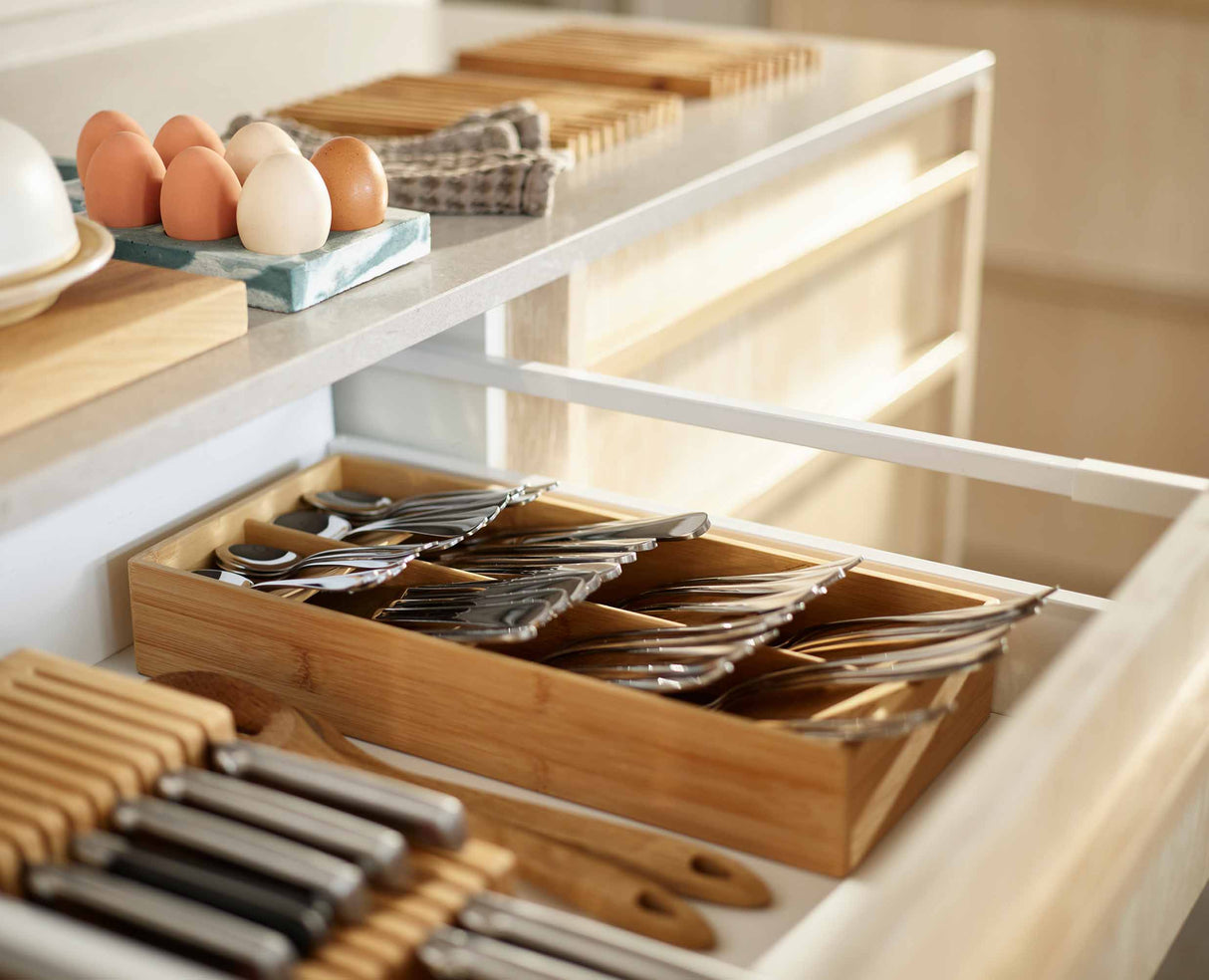 Close-up of the icons marking each cutlery compartment on the bamboo tray.