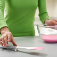 Pink Elevate spatula resting on its weighted handle tool rest.
