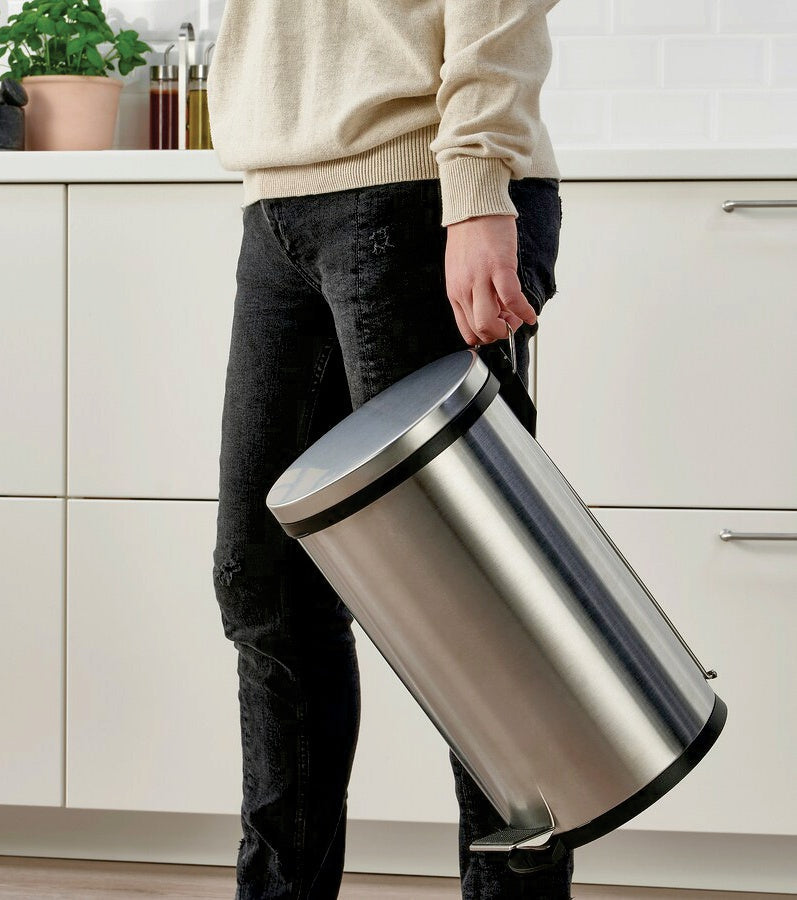Person carrying a Bon Appetit stainless steel pedal bin by its handle in a kitchen
