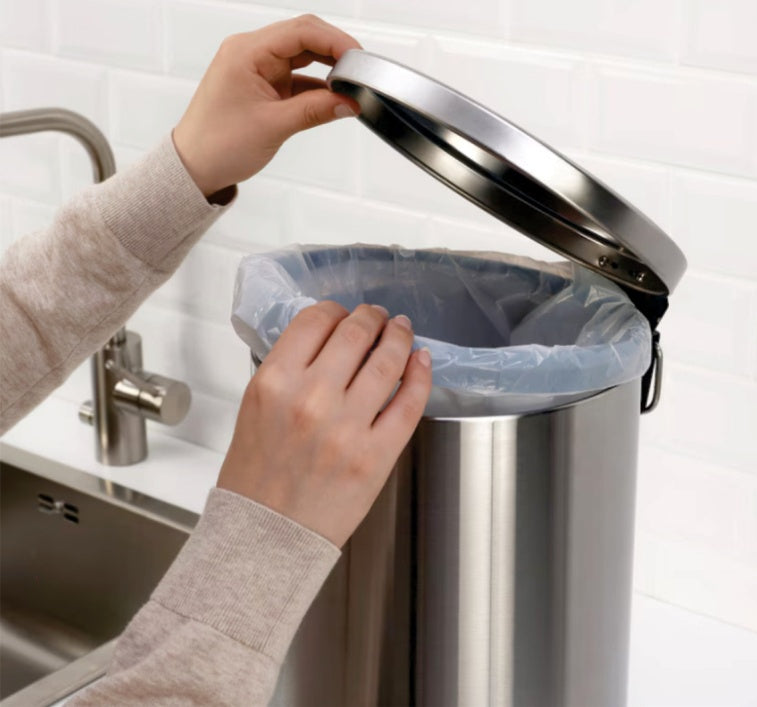 Hands fitting a bin liner into a Bon Appetit stainless steel pedal dustbin