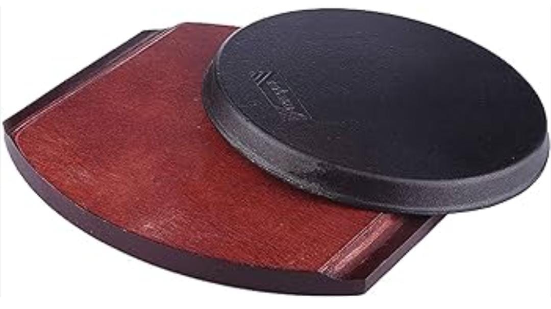 Cast iron hot sizzling plate on wooden tray