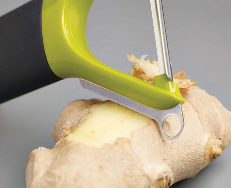 The green Y-shaped peeler angled to show its stainless-steel straight blade