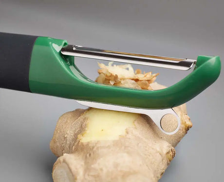 The dark green straight peeler turned to show its stainless-steel peeling blade