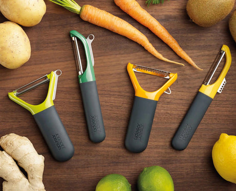 The Multi-Peel straight peeler held in the hand while peeling a vegetable