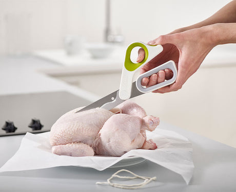 The green PowerGrip scissors open, showing the serrated Japanese stainless-steel blades
