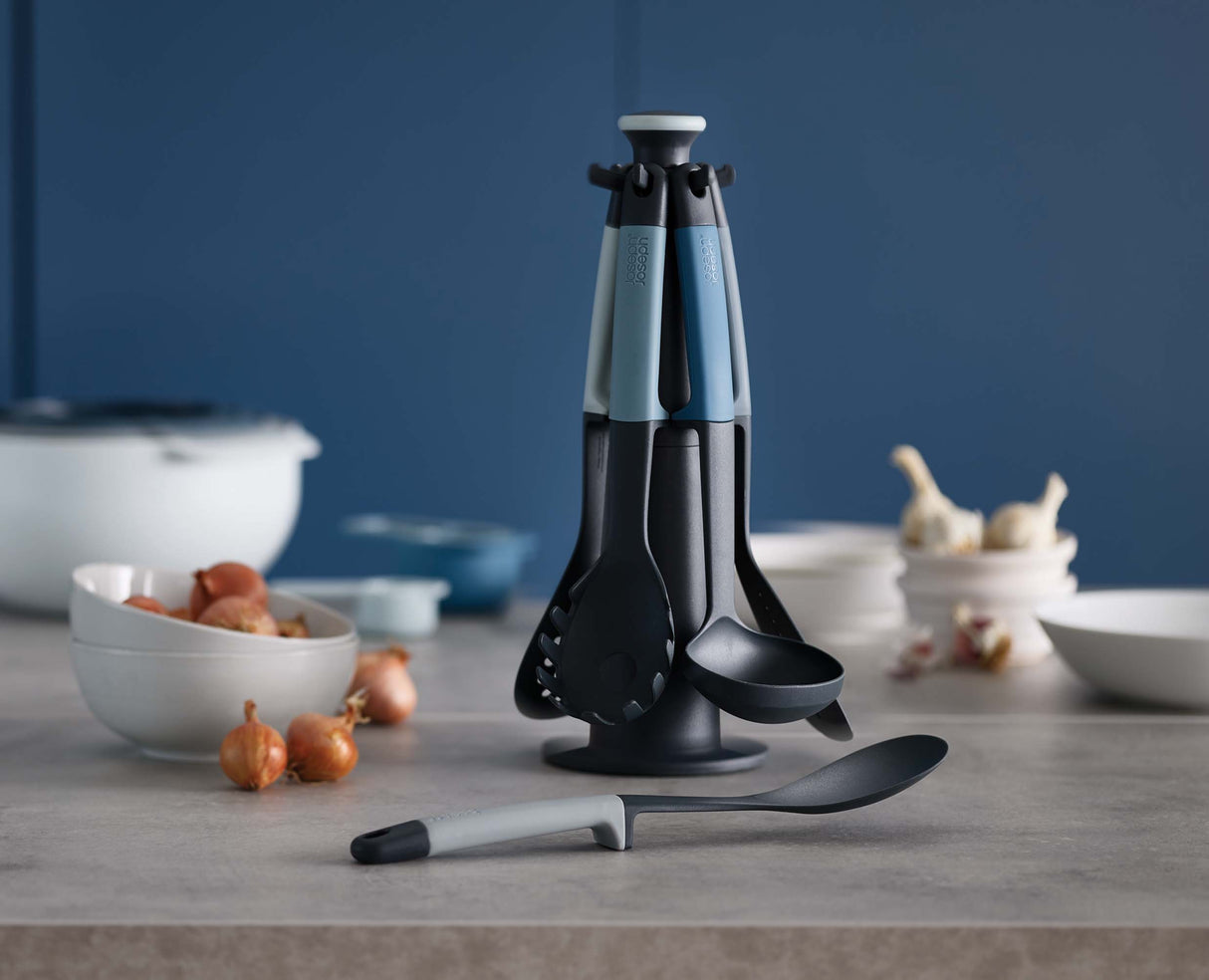 The six blue Elevate tools laid out — slotted spoon, spaghetti server, solid spoon, slotted turner, flexible turner and ladle