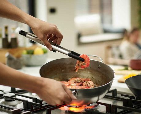 Joseph Joseph Elevate Fusion large tongs gripping food in a pan, Homelux Kenya