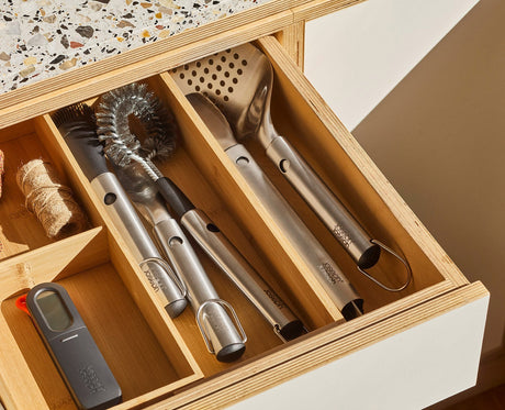 Close-up of the GrillOut tongs, turner, fork and basting brush showing the stainless steel heads.
