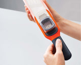 The sliding finger guard in position to protect fingertips while grating.