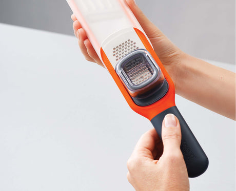 The sliding finger guard in position to protect fingertips while grating.