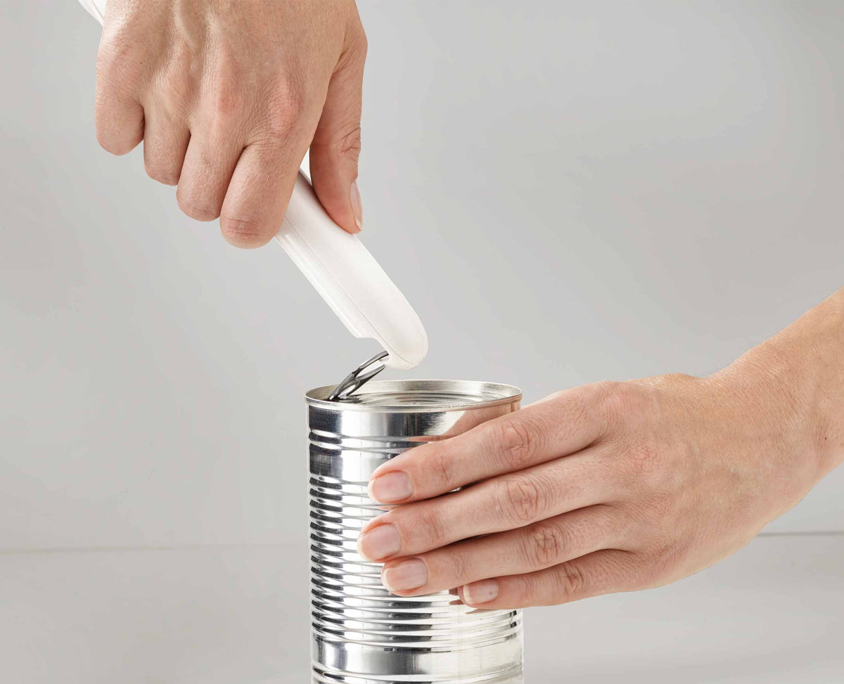 The lid-release button releasing a cut lid from the opener.