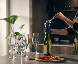 The corkscrew clamped over a wine bottle neck ready to pull the cork.