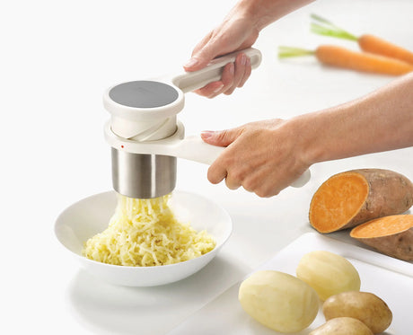 Joseph Joseph Helix potato ricer pressing smooth mashed potato into a bowl