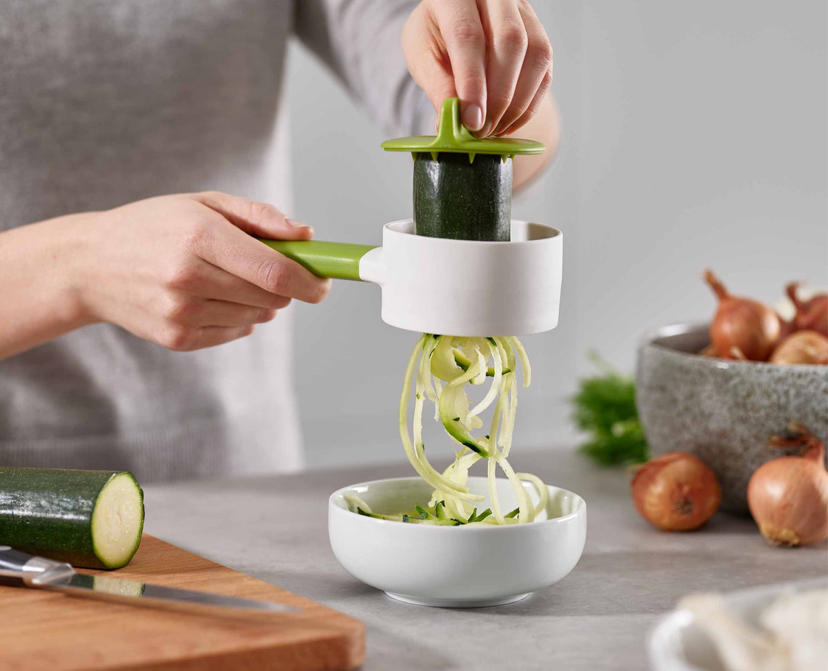 A courgette being twisted into the SpiroGo to form curly noodles.