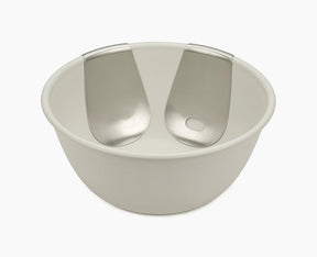 Joseph Joseph Uno salad bowl in stone with both stainless-steel servers hooked onto the rim.