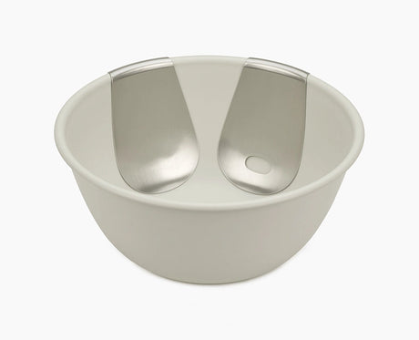 Joseph Joseph Uno salad bowl in stone with both stainless-steel servers hooked onto the rim.