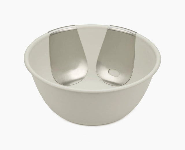 Joseph Joseph Uno salad bowl in stone with both stainless-steel servers hooked onto the rim.
