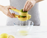 JuiceMax citrus press on a kitchen counter beside fresh limes.
