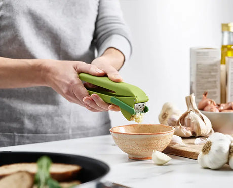 The CleanForce press being squeezed around a garlic clove.