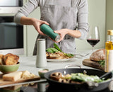Joseph Joseph Milltop salt and pepper mill set in Editions sage green twisting the base to grind, Homelux Kenya