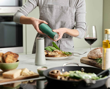 Joseph Joseph Milltop salt and pepper mill set in Editions sage green twisting the base to grind, Homelux Kenya