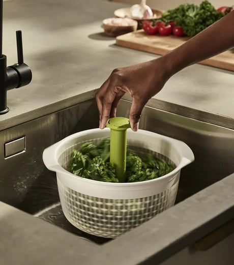 Joseph Joseph Spindola colander attached to the sink base with its suction cup