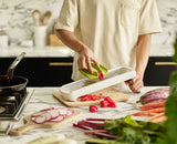 The mandoline's precision food grip holding a potato above the blade.