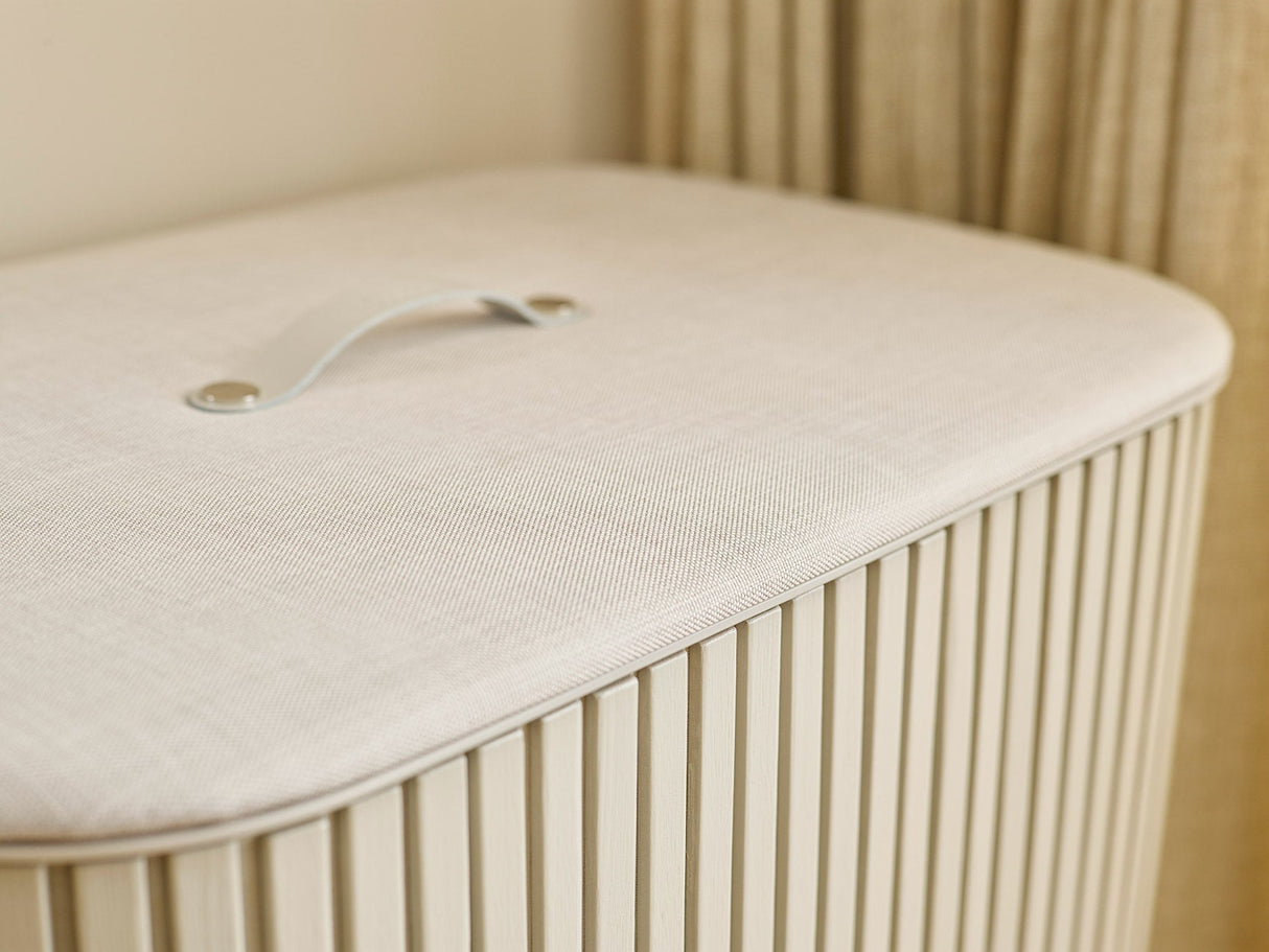 Close-up of the leather handle set into the fabric-wrapped lid.