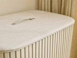 Close-up of the leather handle set into the fabric-wrapped lid.