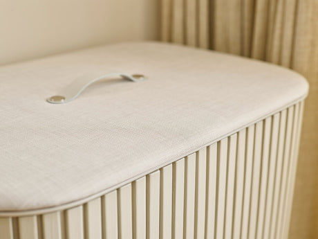 Close-up of the leather handle set into the fabric-wrapped lid.