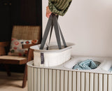 Tote bag emptied into a washing machine using the helper handle on its base.