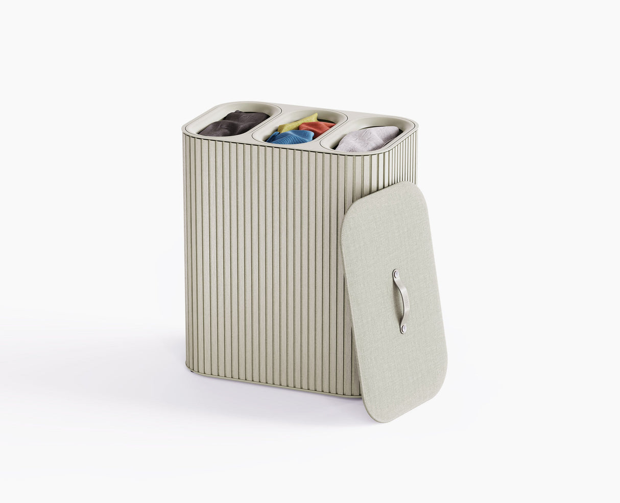 Joseph Joseph Tota Trio Luxe 90L laundry basket in ecru with the bamboo exterior and lid closed.