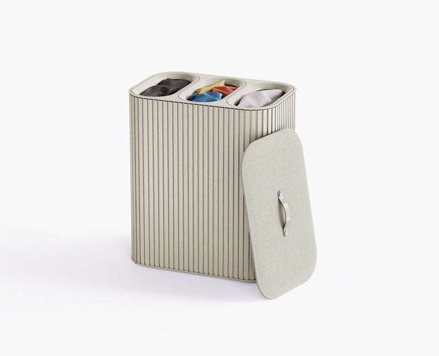 Joseph Joseph Tota Trio Luxe 90L laundry basket in ecru with the bamboo exterior and lid closed.