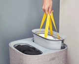 One grey tote bag lifted out of the basket by its fabric handles.
