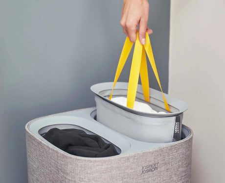 One grey tote bag lifted out of the basket by its fabric handles.