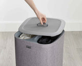 Close-up of the tote bag handles and the plastic rim that holds the bag open.