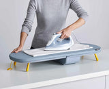 A shirt being ironed on the open Pocket board on a kitchen worktop.