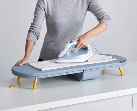 A shirt being ironed on the open Pocket board on a kitchen worktop.