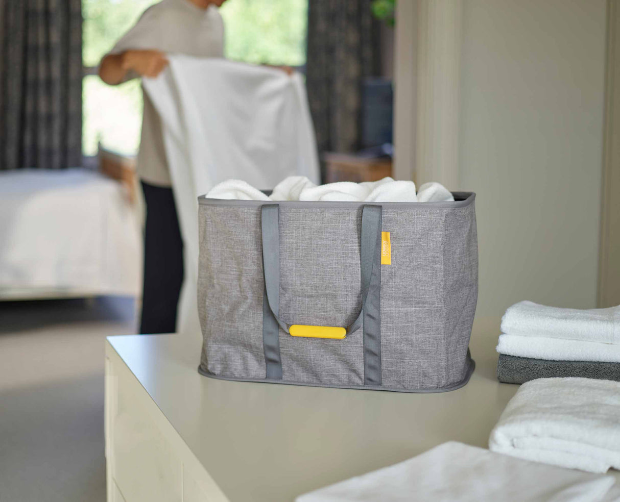 Carrying the Hold-All Max laundry basket one-handed by its side handle