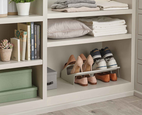 The ecru shoe rack in a hallway beside a front door.