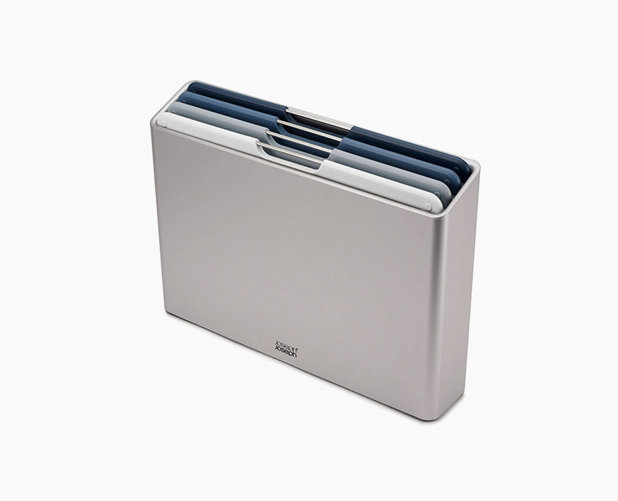 Joseph Joseph Folio Editions four-piece chopping board set in blue, boards stacked in the slimline case.