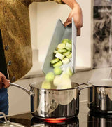 The Chop2Pot board squeezed into its folded chute shape by the handle.