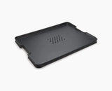Joseph Joseph Cut&Carve Plus extra-large chopping board in black, spiked carving side up.