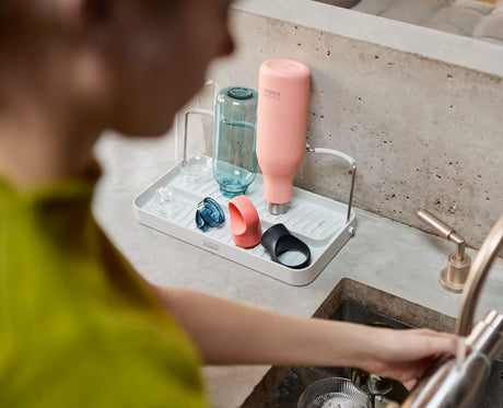 Joseph Joseph DrySmart folding bottle drying rack in stone holding four bottles and lids, Homelux Kenya