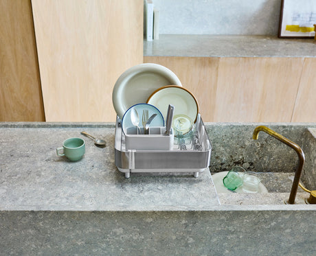 Joseph Joseph Extend Steel Plus expandable dish rack in stone rail folded down to drain bottles, Homelux Kenya