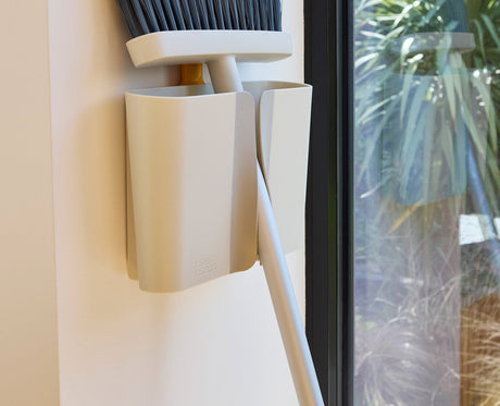 The bristle comb being used to pull trapped hair from the broom head.