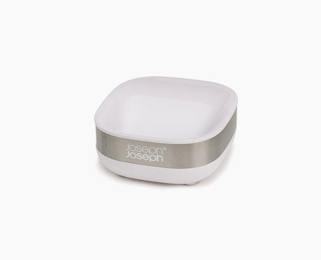 Joseph Joseph Slim compact stainless-steel soap dish in white, holding a bar of soap.