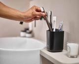 The matt black caddy on a bathroom basin surround.